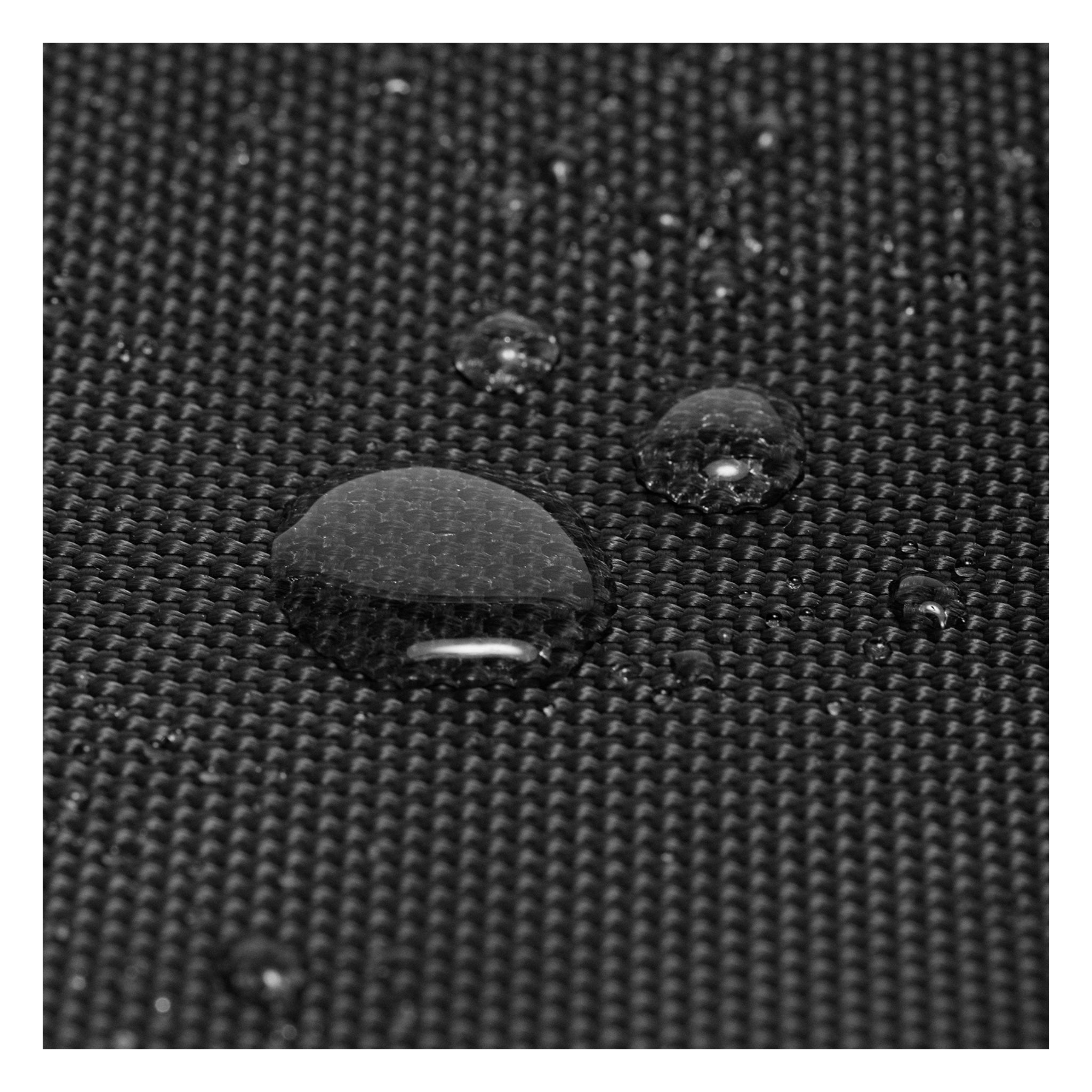 Macro shot of water droplets on the black Weekend Bag's water-resistant fabric, showcasing durability